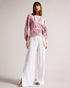 EMILIAH-Tops-Add some spring florals to your wardrobe with our EMILIAH blouse, which features a wrap front and blouson sleeves. Smocked shoulders give the piece extra texture without the bulk.The fabric of this product is made with 100% recycled polyester. Using recycled polyester helps divert plastic waste from ending in landfills, and helps us to reduce our dependence on virgin materials. Blouse Wrap front Blouson sleeves Smocked shoulders Blurred floral print Self tie waist V-neck Julia is 5'10" / 1.78m